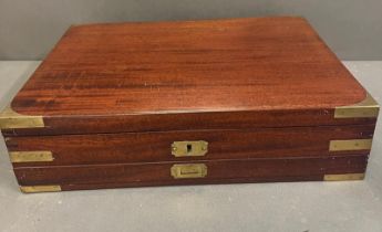 A mahogany campaign box with brass banding opening to leather lined lid and fitted interior