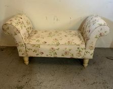 A fabric covered, rose pattern, window seat on turned cream legs (H 66cm x 47cm D 130cm W)