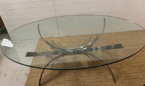 A contemporary glass dining table on brushed chrome sculptural legs (210cm x 128cm x 75cm)
