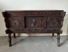 A vintage oak Indian carved Damchiya chest (H83cm W124cm D60cm)