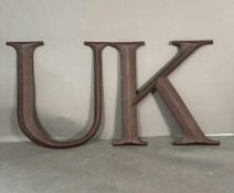 Two metal wall hanging letters, U and K