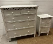 A white painted two over three chest of drawers and matching bedside table
