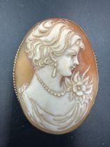 A 9ct gold cameo brooch with lady in pearl necklace and flower.