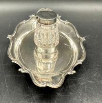 A cut glass inkwell with silver lid on a silver tray both hallmarked for Birmingham 1905