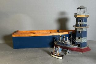 A selection of maritime models. Three boats and a lighthouse