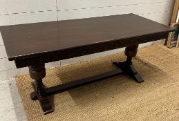 A Mid Century oak coffee table on carved supports with cross stretches (H55cm W133cm D57cm)