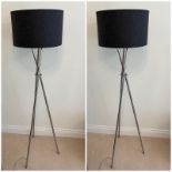 A pair of stand lights on chrome tripod legs and black shades