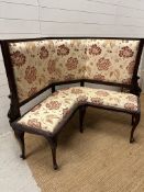 A Victorian mahogany framed corner bench upholstered in a white ground and floral pattern (H107cm