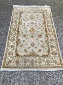 A beige ground rug with floral pattern and geometric boarder (120cm x 190cm)