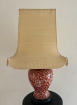 An Oriental lamp base on wooden stand, red grounds H 49cm