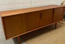 A Danish Mid Century sideboard comprising of four cupboards with sliding doors and three central