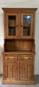 A pine two cupboard and two door dresser with glazed cupboard over (H201cm W91cm D50cm)