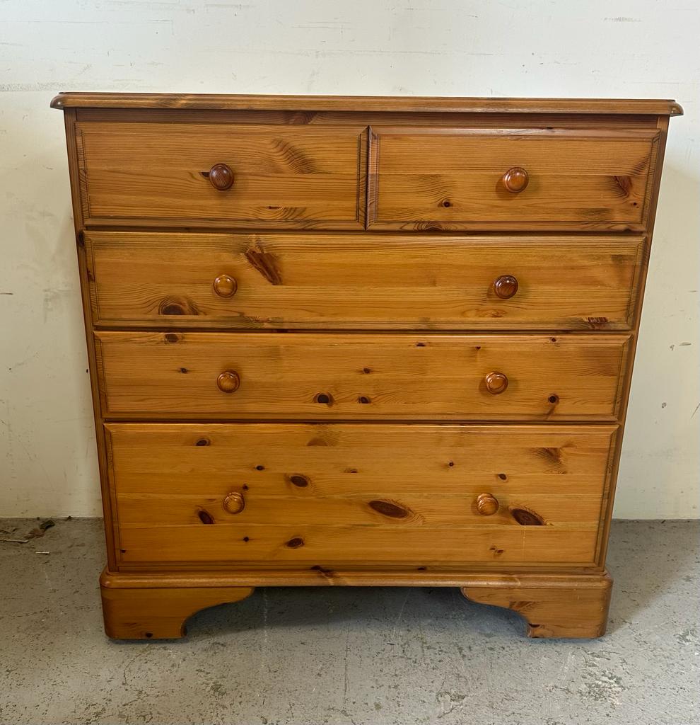 A Ducal two over three pine chest of drawers on castors with a gallery relief (H90cm W87cm D44cm)
