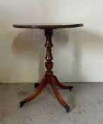 A mahogany circular side table with string inlaid on lion paw feet and castors (H65cm Dia54cm)