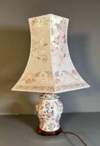 A ceramic painted table lamp with flower and butterfly detail