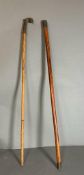 Two Chinese walking canes one with a head handle and the other with a an engraved and signed top.