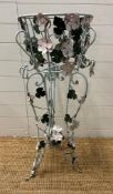A wrought iron plant stand with leaf and flower detail painted in pinks and green (H103cm)