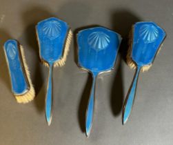 A blue enamel and silver, hallmarked for Birmingham dressing table set comprising three brushes