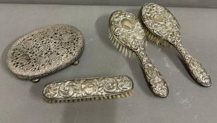 An Indian silver stand and three piece silver brush set