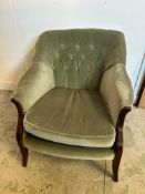 A Mid Century button back arm chair upholstered in green