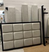 A queen sized bed with a wall hanging grey block headboard