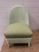 A green Lloyd Loom bedroom chair