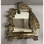 A metal dressing table mirror with peacock to one side (43cm x 35cm)