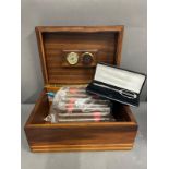A cigar humidor case along with a cutter and sixteen cigars