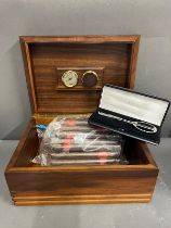 A cigar humidor case along with a cutter and sixteen cigars