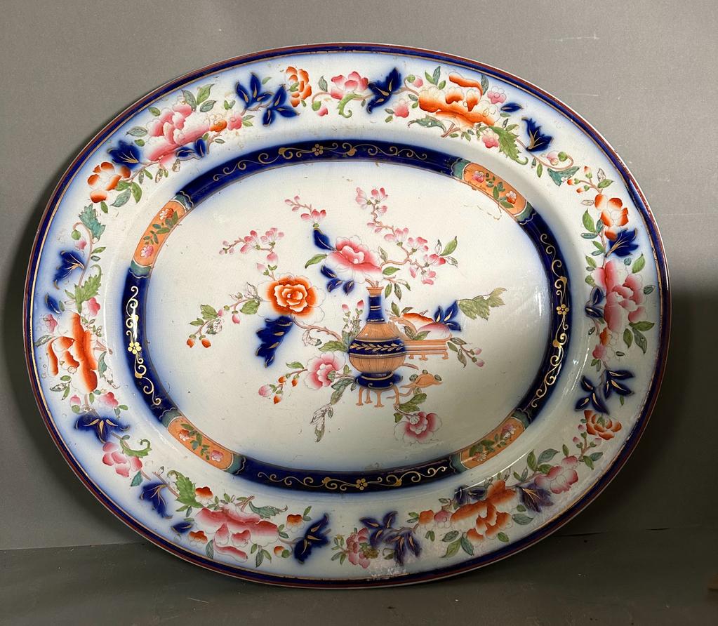 A large painted meat platter or charger with central floral vase and floral border. 54 x 46