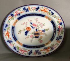 A large painted meat platter or charger with central floral vase and floral border. 54 x 46