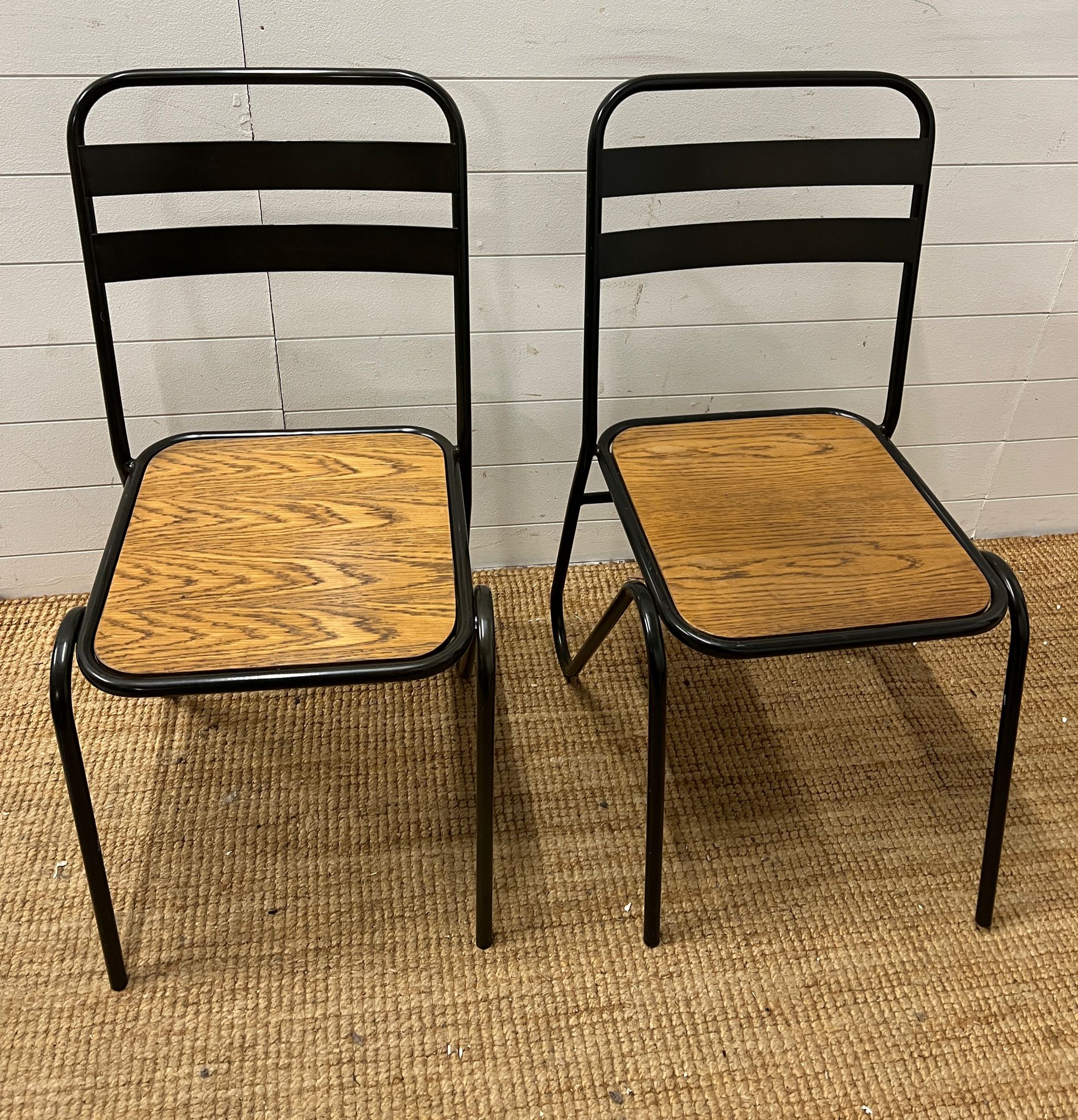 A pair of contemporary industrial style sacking chairs with wooden seat and metal hair pin style