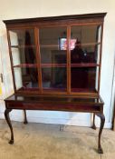 A Mahogany display cabinet comprising of three cupboards with shelves and a glazed display under (