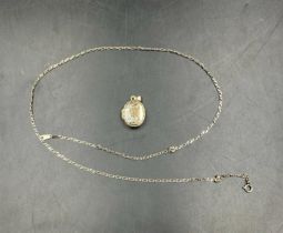 A 9ct gold chain along with an oval locket (Chain weight 1.6g)