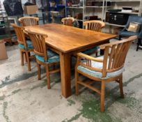 An oak dining table with four chairs and two carvers