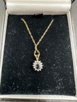 A 9ct gold fine chain with diamond and precious stone pendant.