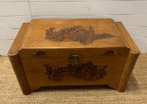 A Chinese carved camphor chest with brass fittings and lock