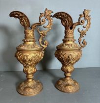 A pair of metal jugs in a classical style.