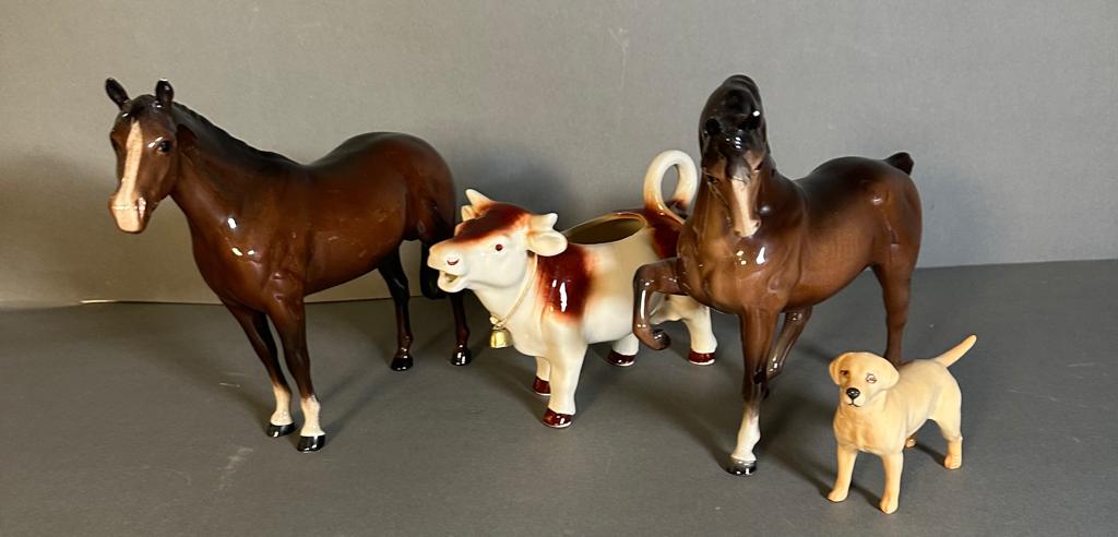 A selection of three Beswick figures and a cow creamer