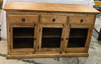 A pine sideboard with three drawers and cupboards under with metal grill fronts (H91cm W153cm