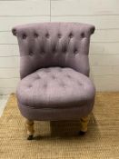 A button back bedroom chair in lilac upholstery
