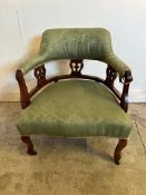 A Victorian style oak framed tub chair on castors with green upholstery