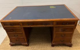 A Pedestal desk with leather top on bracket feet