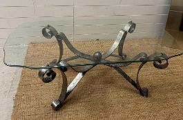 A glass topped coffee table on wrought iron scrolling legs Height 46 131 x 65