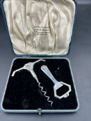 A silver bottle opener and cork screw by Wakely & Wheeler, boxed and hallmarked for London 1932.