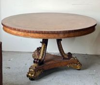 A Regency style centre table, three ornate scrolling legs on a concave platform base with carved