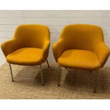 A pair of Mid Century mustard upholstered arm chairs on chrome legs