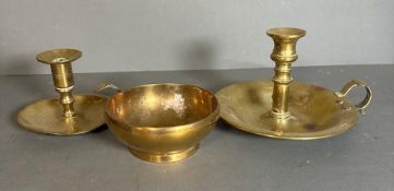 A selection of three brass items to include candle sticks and a bowl