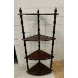 A mahogany four tier corner stand on turned supports (H110cm D30cm W50cm)