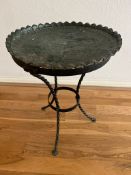 A wrought iron based side table with ornate metal top (H 52cm x D 36cm)